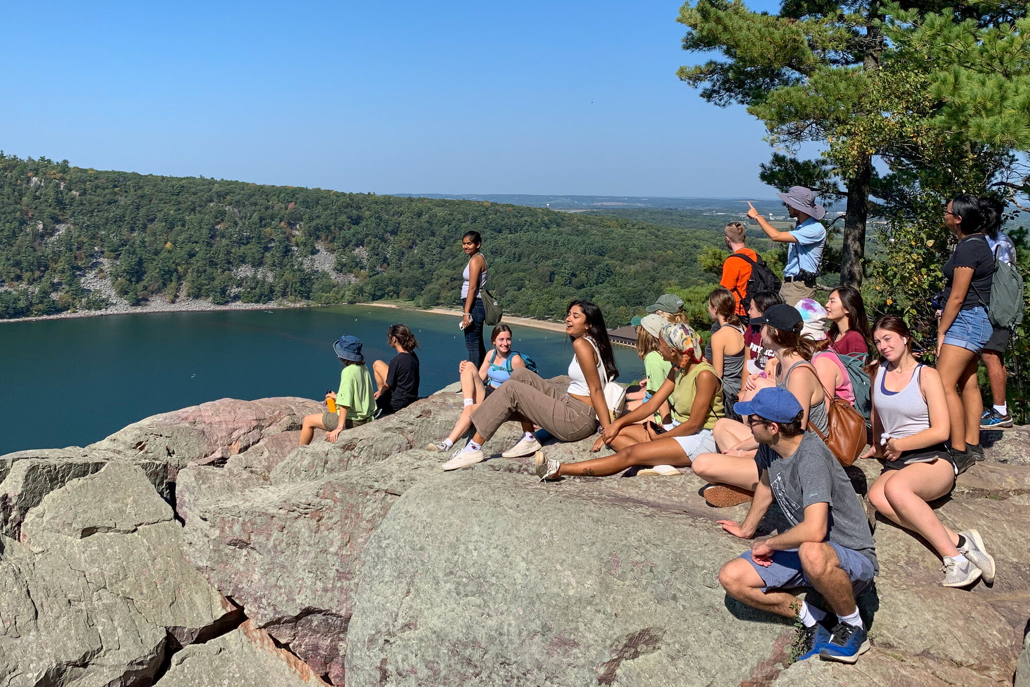 A group of students looking at a view off a rocky cliff.