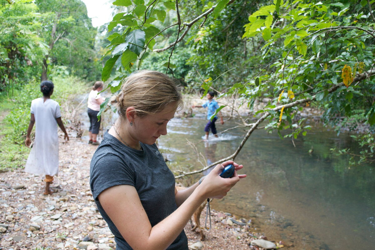 A student looking at a digital instrument in the field.